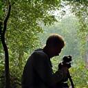 A wildlife photographer discreetly capturing a rare bird species.
